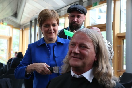 Nicola Sturgeon, First Minister of Scotland, cutting the hair of David Torrance MSP, The Scottish Parliament, Edinburgh, Scotland, UK - 05 September 2019