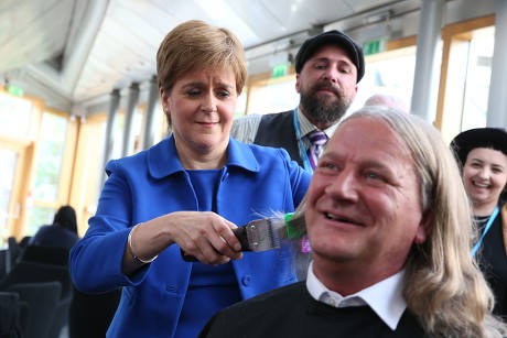 Nicola Sturgeon, First Minister of Scotland, cutting the hair of David Torrance MSP, The Scottish Parliament, Edinburgh, Scotland, UK - 05 September 2019