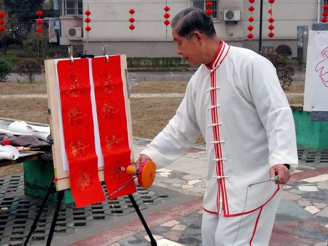 Men create new way of writing Chinese calligraphy using a yo-yo, Nanjing, Jiangsu province, China - Feb 2010