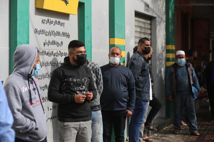 Palestinians wear protective face masks, as they wait to receive their financial aid, amid the coronavirus, Dair Al Balah, Gaza Strip, Palestinian Territory - 04 Feb 2021