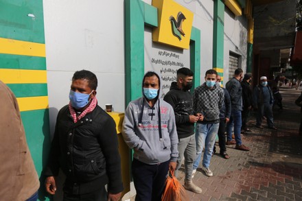 Palestinians wear protective face masks, as they wait to receive their financial aid, amid the coronavirus, Dair Al Balah, Gaza Strip, Palestinian Territory - 04 Feb 2021