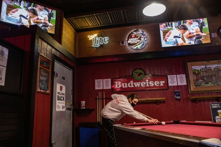 Patron of Pawpurr's Bar plays pool table during the Super Bowl LV march  between the Kansas City Chiefs and the Tampa Bay Buccaneers. Students and  residents of Athens, Ohio watch the Kansas