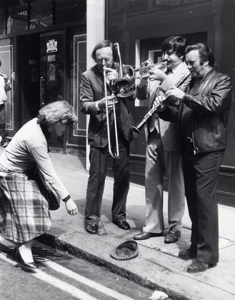 Kenny Ball And His Jazzmen Are Seen Busking On The Street. Chris Barber And Acker Bilk.