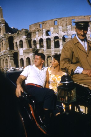 August 1960: US hammer thrower Harold "Hal" Connolly and his wife, US discus thrower (one-time Czech competitor) Olga Fikotova, in Roman horse carriage riding towards the Coliseum, 1960 Rome Olympic Games, Rome.