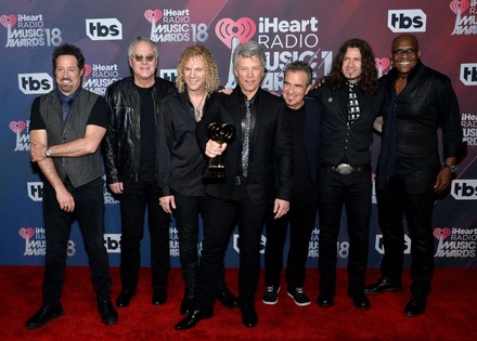 (L-R) John Shanks, Hugh McDonald, David Bryan, Jon Bon Jovi, Tico Torres, Phil X, and Everett Bradley of Bon Jovi, recipients of the Icon Award, appear backstage during the iHeartRadio Music Awards at The Forum in Inglewood, California on March 11, 2018. Turner's TBS, TNT, and truTV channels broadcasted the ceremony live from The Forum.