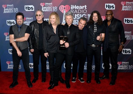 (L-R) John Shanks, Hugh McDonald, David Bryan, Jon Bon Jovi, Tico Torres, Phil X, and Everett Bradley of Bon Jovi, recipients of the Icon Award, appear backstage during the iHeartRadio Music Awards at The Forum in Inglewood, California on March 11, 2018. Turner's TBS, TNT, and truTV channels broadcasted the ceremony live from The Forum.