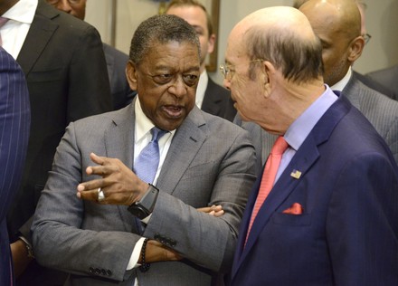 BET co-founder Robert L. Johnson (L) chats with Commerce Secretary Wilbur Ross prior to President Donald Trump signing an executive order establishing The White House Opportunity and Revitalization Council during a ceremony at the White House, Washington, DC, December 12, 2018. The council will assist economically distressed communities, chaired by Carson.