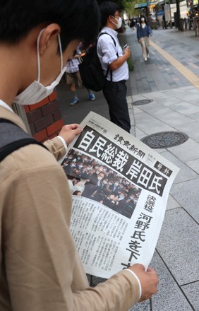 People receive extra edition newspapers which report Fumio Kishida won the presidential election of the ruling Liberal Democratic Party, Tokyo, Japan - 29 Sep 2021