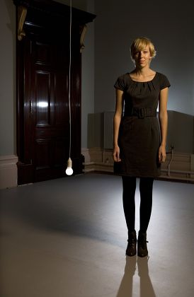 Artist Katie Paterson photographed with her 2008 work ' Light bulb to Simulate Moonlight ' at the Haunch of Venison Gallery in Central London.