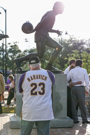 July 25, 2022: Jackie Maravich poses with a small statue with her son's  Josh Maravich and Jaeson Maravich during the ceremony to unveil the new Pete  Maravich statue at the Pete Maravich