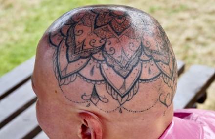 Minimalist rose head tattoo on the upper back