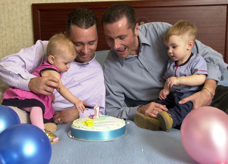 Saffron Drewitt-barlow (l) And Aspen Drewitt-barlow With Their Parents Barrie Drewitt And Tony Barlow. In Sweden Celebrating The Twins' First Birthday With A Cake And Balloons. The Homosexual Fathers Have Just Announced That They Are To Launch A Ii1