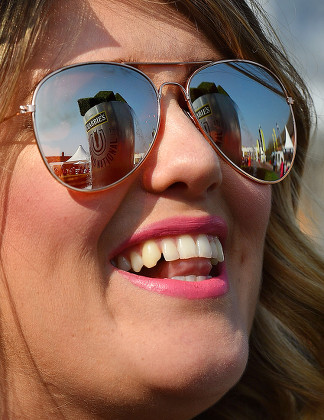 Pic Bruce Adams / Copy Tozer -9/4/15 Day1 - Grand National Meeting At Aintree Racecourse Merseyside.- Hot Weather Pix - Grand National Sign Reflected In Sunglasses Of Race Goer Sarah Evans From Liverpool.