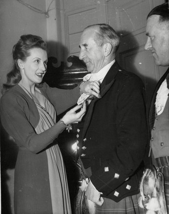Actress Anne Crawford Fastens The 'captain's Badge' On Her Father Captain Thomas Crawford At The Heather Club Annual Dinner. Box 648 602121539 A.jpg.
