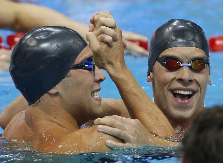 Winner Matthew Grevers (l) of the United States of America (usa) and His Teammate Second Placed Nick Thoman (r) Celebrate After Competing in the Men's 100m Backstroke Final While 4th Placed Camille Lacourt (front) of France is Disappointed During the Swimming Competition Held at the Aquatics Center During the London 2012 Olympic Games in London England 30 July 2012 United Kingdom London