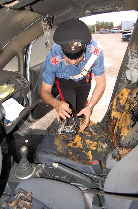 An Italian Policeman Looks Inside the Ruined Interior of a Car in Bari 26 June 2009 Belonging to a Woman Linked to Sex Scandal That Has Engulfed Italian Premier Silvio Berlusconi the Car was Set Alight Late 25 June 2009 in a Suspected Arson Attack According to News Reports the Torching Took Place in Modugno Near the Southern City of Bari Outside the Home of 23 Year Old Barbara Montereale Italy Bari