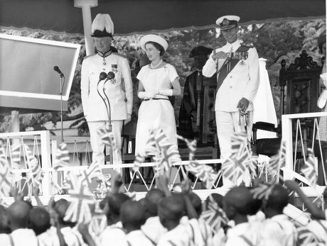 The Queen (queen Elizabeth Ii) And Duke And Governor Of Gambia (sir Edward Windley) Stand On The Royal Dias In Macathy Square Bathurst And Acknowledge The Greeting Given Them By The Children. Lp3d Tour Of Gambia December 1961