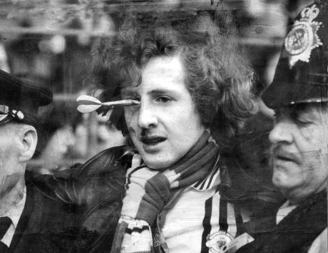 Peter Brookes Is Carried Away By The Police After Getting A Dart In His Eye During The Liverpool V Manchester United Match In February 1978.