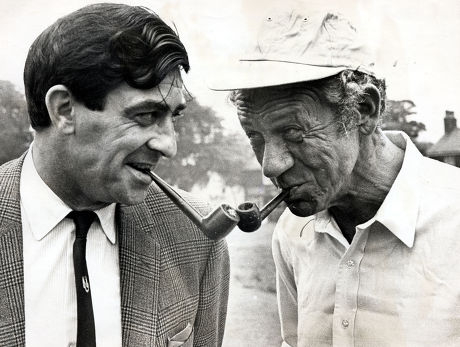 Fred Trueman (1931-2006) Yorkshire And England Cricketer With Actor Sid James Both With Pipes. They Met During Filming For A New Thames Tv At Wrea Green In Lancashire.