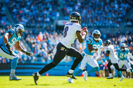 Baltimore Ravens quarterback Lamar Jackson (8) takes to the field with a  member of the military as part of Salute to Service before an NFL football  game against the Carolina Panthers, Sunday