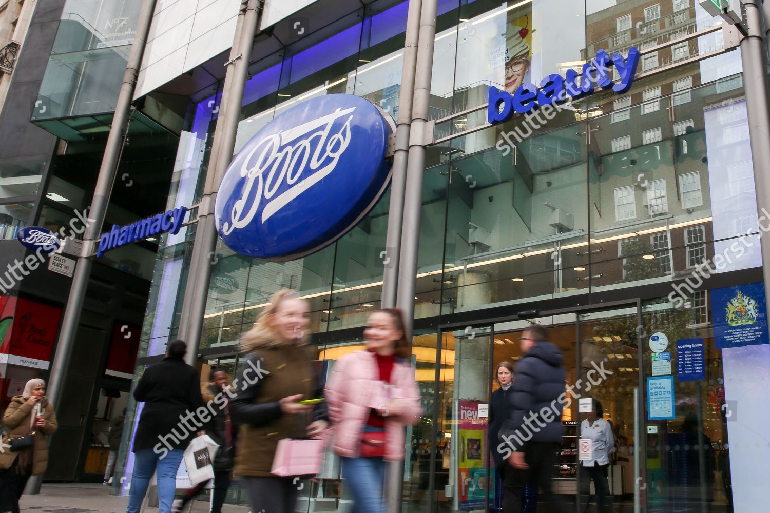 Shoppers walk past Boots store on Oxford Editorial Stock