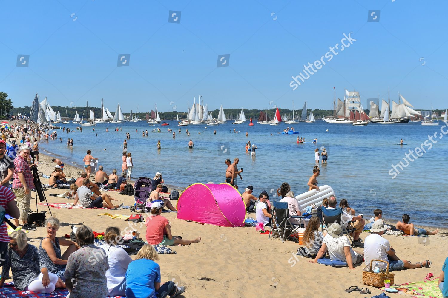 Sunbathers Observe Traditional Sailing Ships During Windjammer