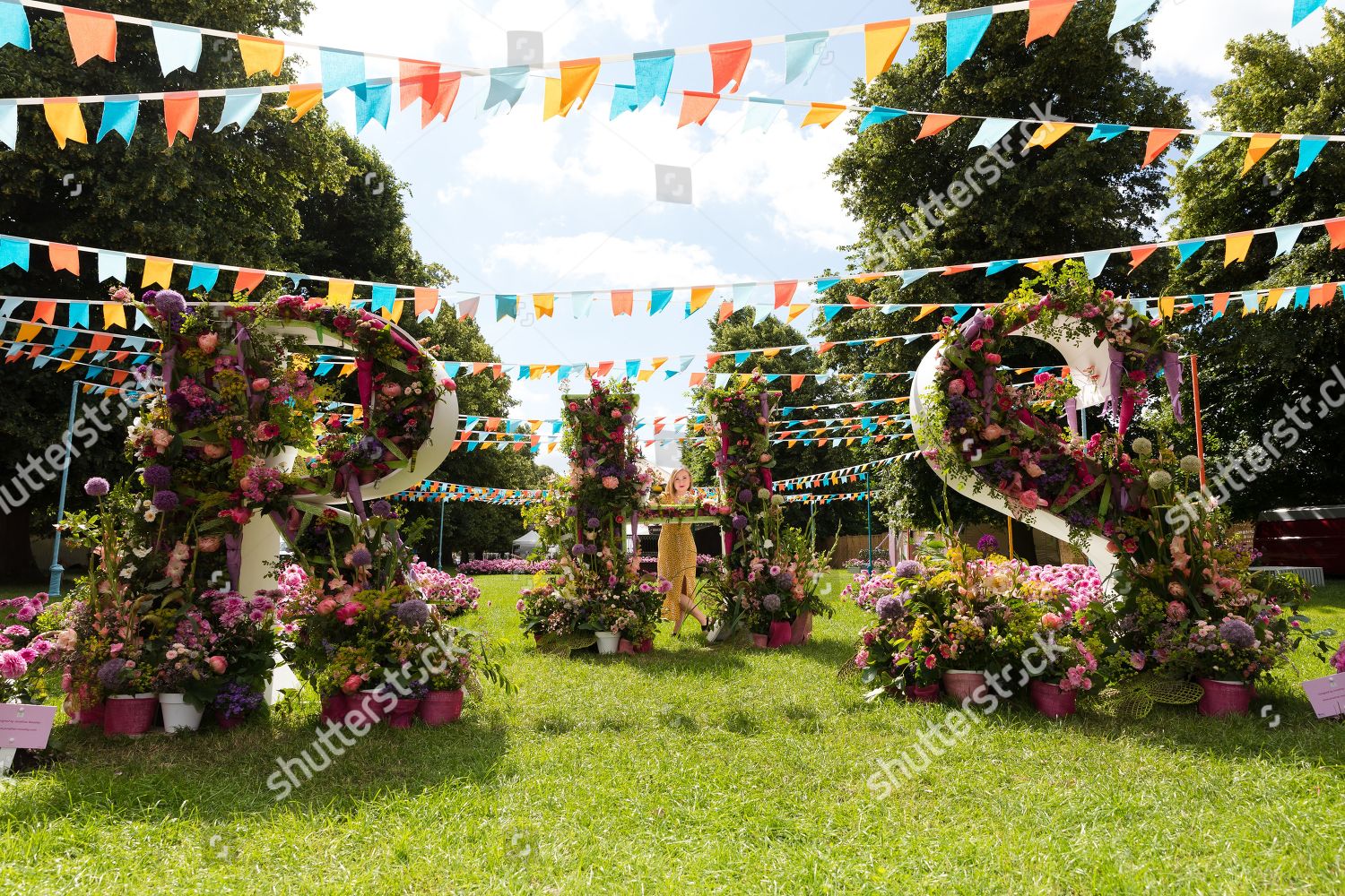 Woman Poses Behind Flower Display During Press Editorial Stock