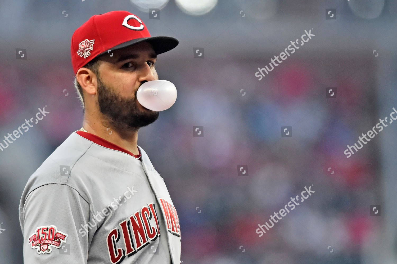 Cincinnati Reds' Eugenio Suarez blows a bubble with his gum as he