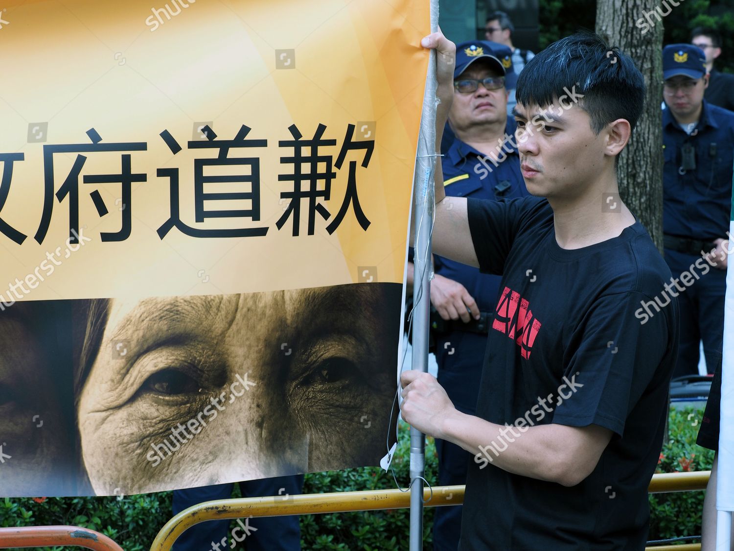 Protester Holds Banner Which Reads Japanese Government Editorial