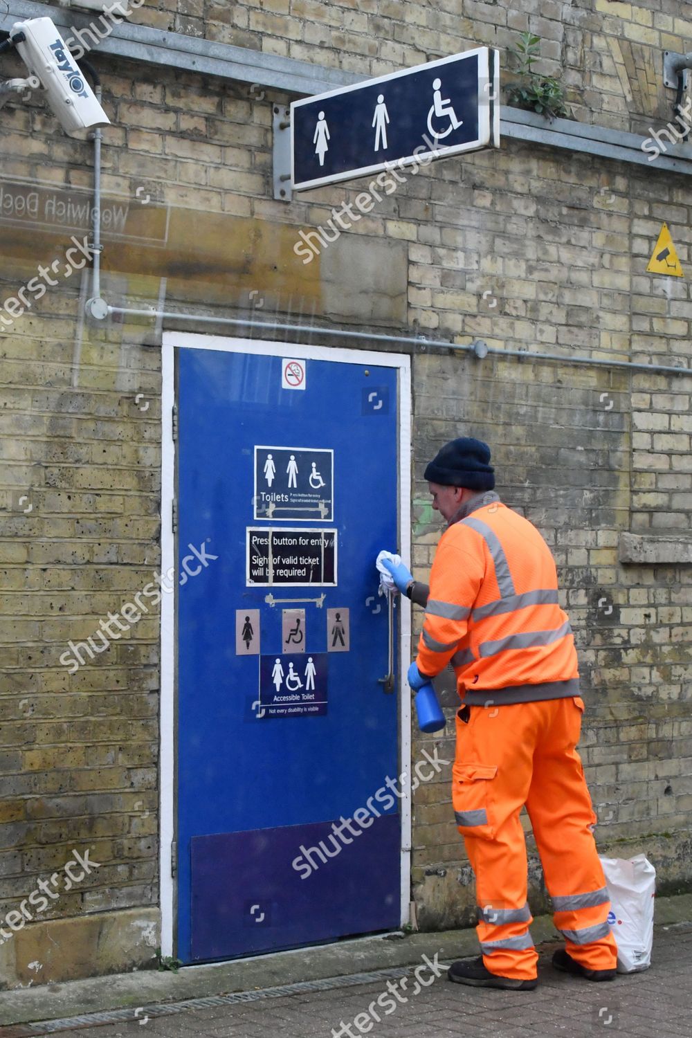 Cleaning train station toilet door handles editorial stock photo