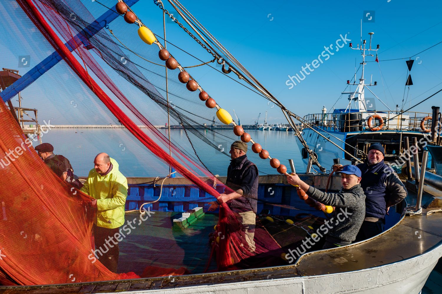 sailboat vs fishing boat hauling nets