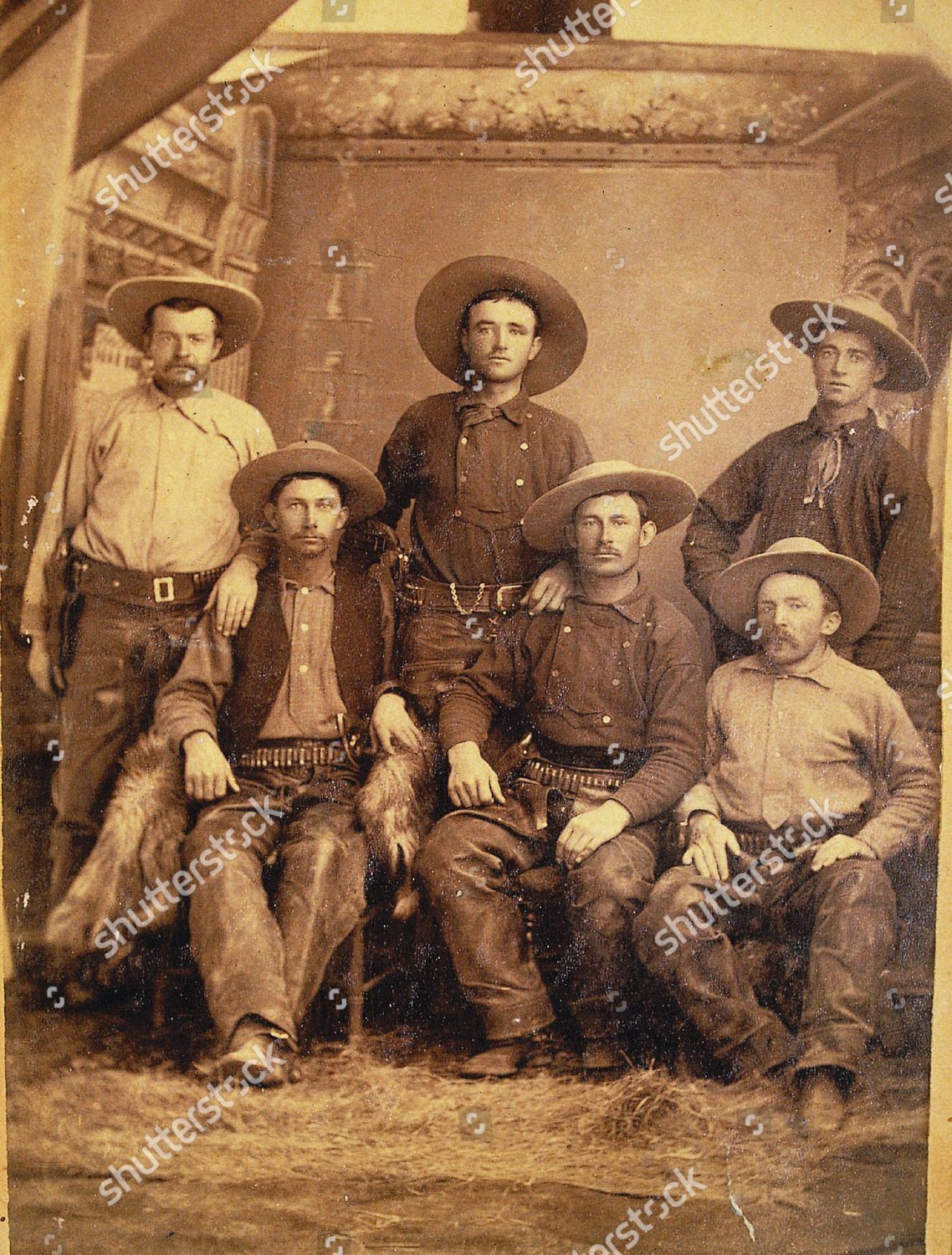 Arizona cowboys, 1880, dressed in the typical costume of the time, including low crown "Boss of the Plains" Stetsons, shotgun style chaps and vests, and some are wearing double-breasted or bib-front shirts. (standing, left to right) James Prusley, Walter Fife, James Maxwell; (seated, left to right) Billy Riggs, James McClure, Judge John Blake.