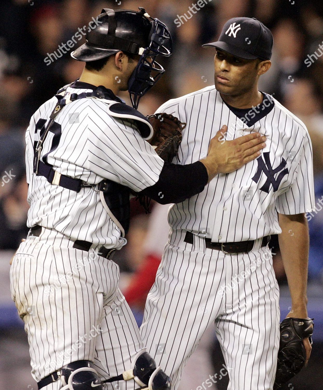 New York Yankees catcher Jorge Posada (R) is congratulated after