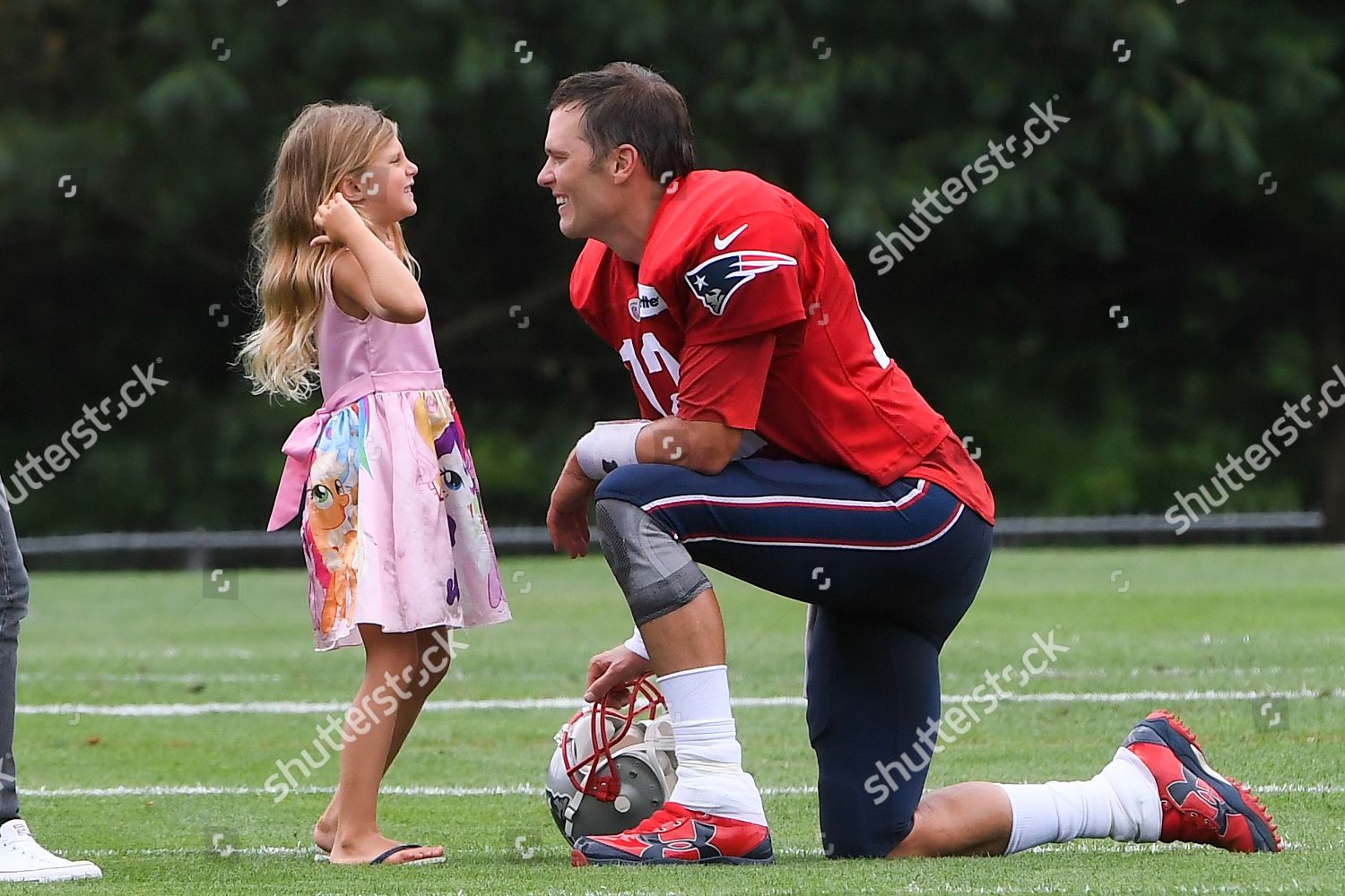 New England Patriots quarterback Tom Brady (12) wipes the sweat off his  face during practice on the second day of training camp at the NFL football  team's facility in Foxborough, Mass., Friday