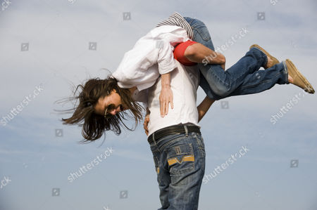 Stock Picture of Model released - Girl carried over mans shoulder fun.